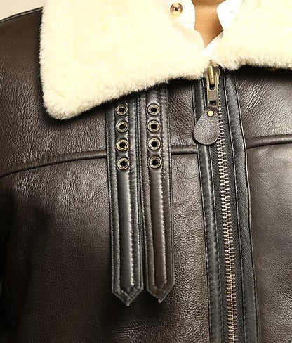 Close-up of a black leather jacket with white fur lining and decorative buttons.