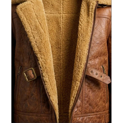 Close-up of a brown faux-leather jacket with a thick tan sherpa fleece lining, showing the collar, front zipper, and side pockets with buckle details.
