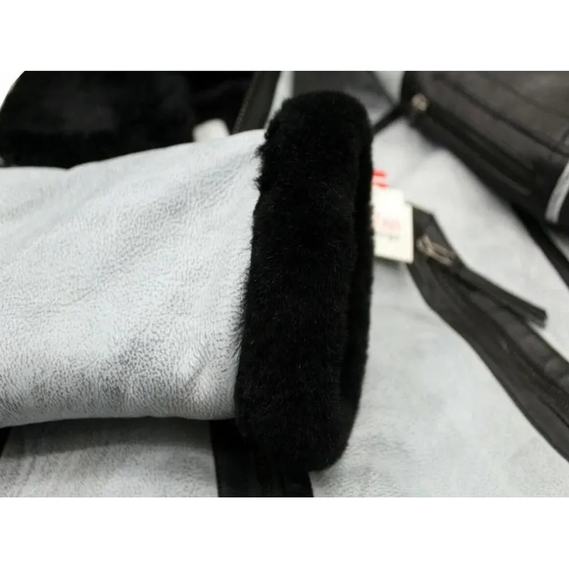Black car handbrake cover on a car interior with a white towel.